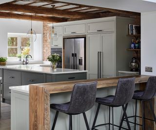 kitchen with beamed ceiling, sage green units and island unit with seating area