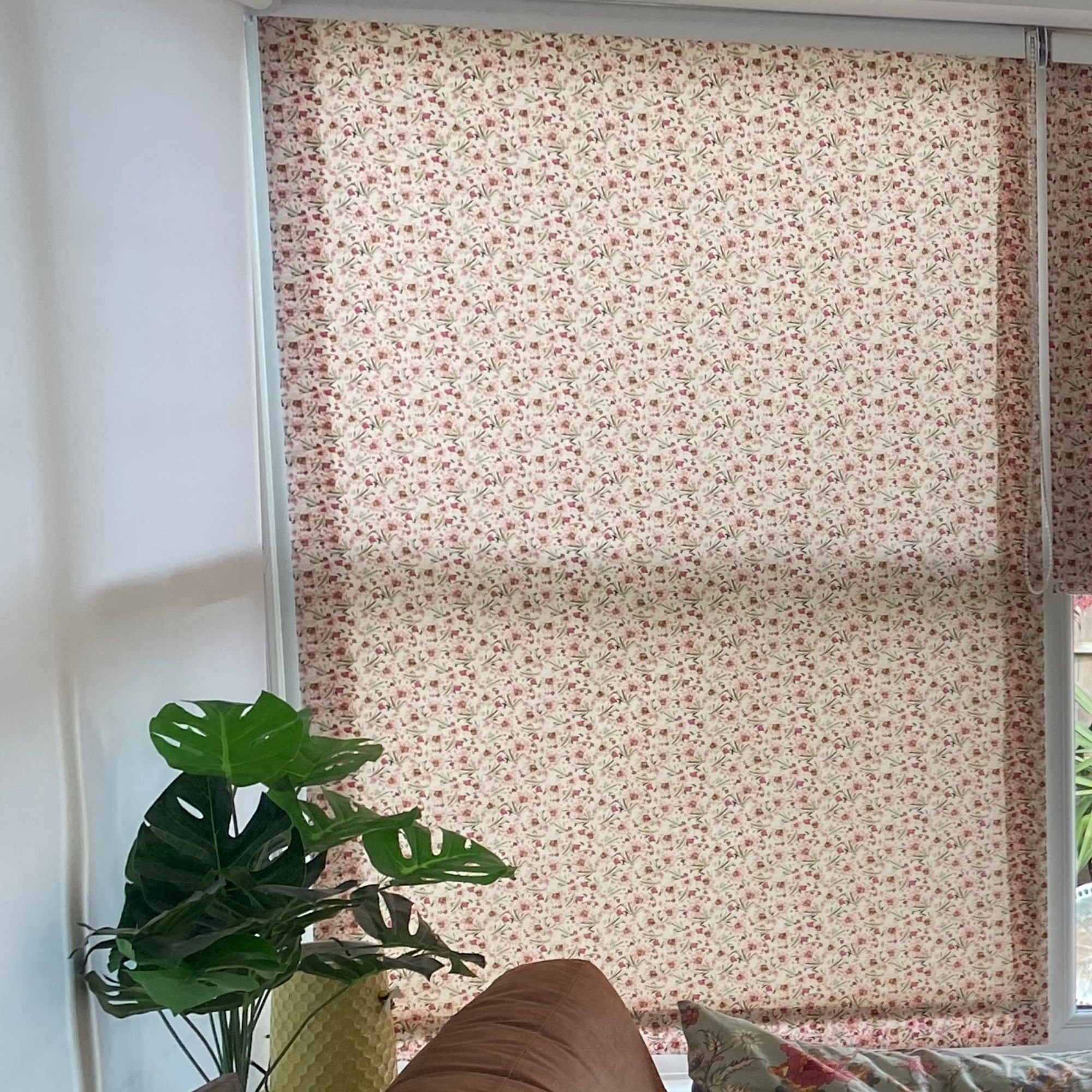Fabric cover on top of a conservatory blind with a green faux plant in the corner