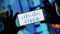Hands hold mobile phone with Cisco logo on the screen
