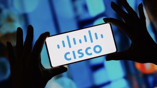 Hands hold mobile phone with Cisco logo on the screen