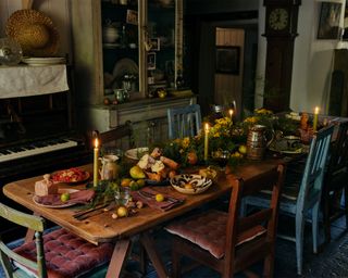 Country dining room / kitchen with christmas table, decorated with candles, gifts and foliage