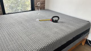 Layla Hybrid mattress with a weight and tape measure resting on it