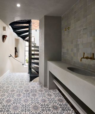 wrought iron spiral staircase down to underground wash room with tiled floor