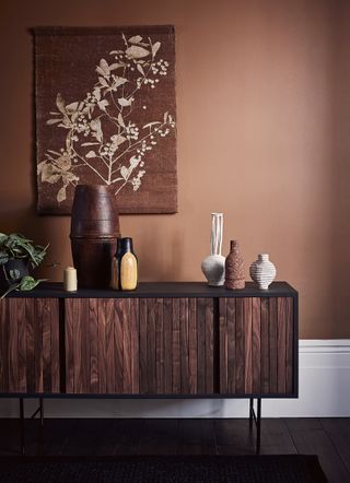 Brown room with wooden sideboard and wall hanging