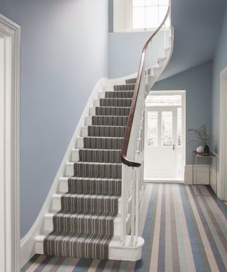 blue, cream, grey and brown striped carpet in hallway and repeated in a narrower striped pattern on stairs