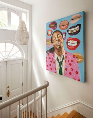 a bold artwork in the hallway of a white walled rental house