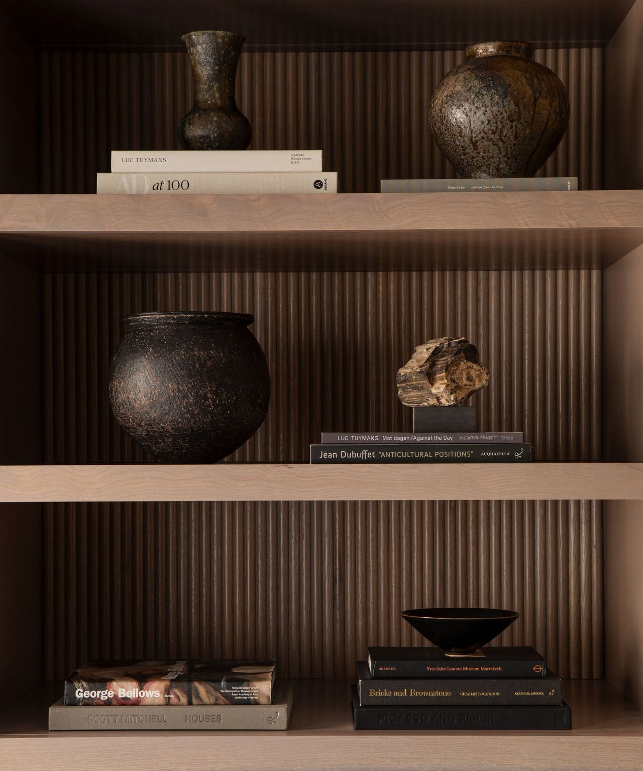 A moody home office's built-in wooden shelving