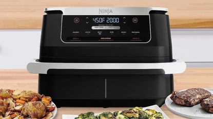 Ninja Foodi 6-in-1 air fryer on a countertop with air fried foods on plates around it