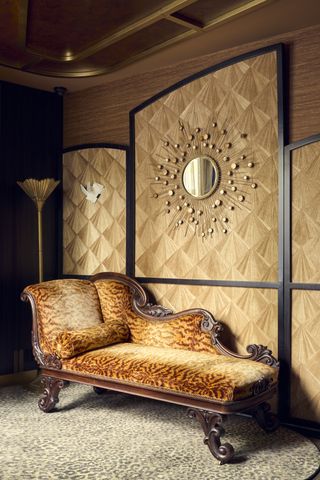 art deco room with leopard print chaise lounge, leopard print carpet, wall panelling, art deco mirror and gold floor lamp