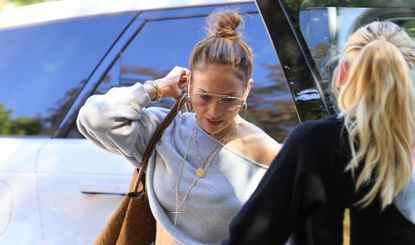 Jennifer Lopez in Los Angeles wearing a cutoff shirt with a suede Bottega Veneta bag and platform combat boots