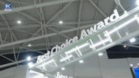 A photo of the Computex Best Choice Award stand, showing the title against a background of lights and sheet metal roofing, in Taiwan