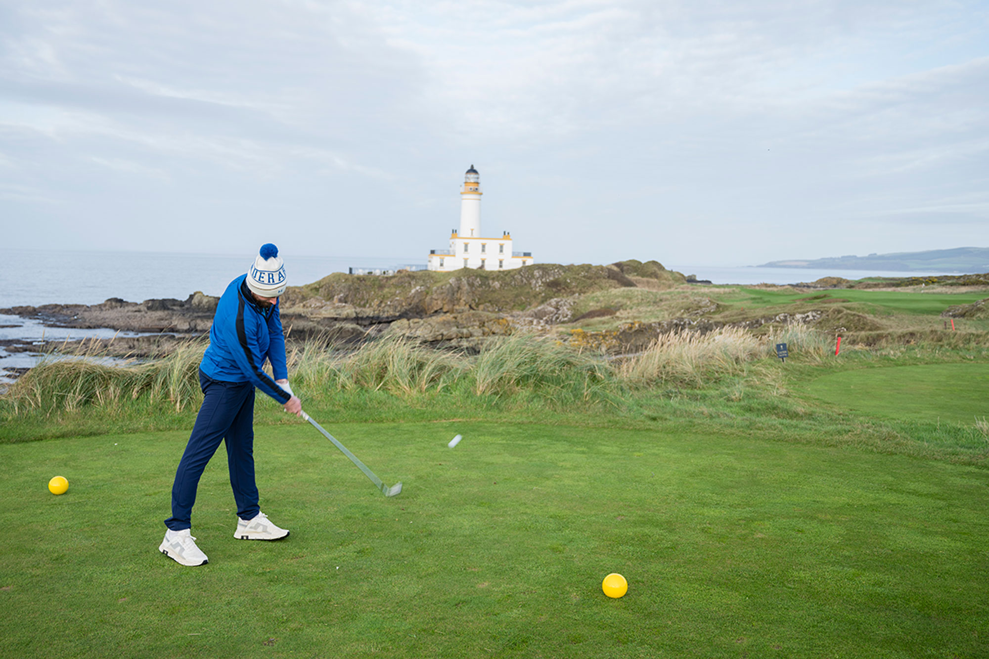 Barry Plummer hitting a tee shot on the par-3 9th hole at Turnberry, in front of the famous lighthouse