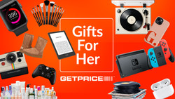 Words say Gifts for Her on red and orange background with items spread around the background including kindle, airpods, ugg boots, record player and makeup brushes