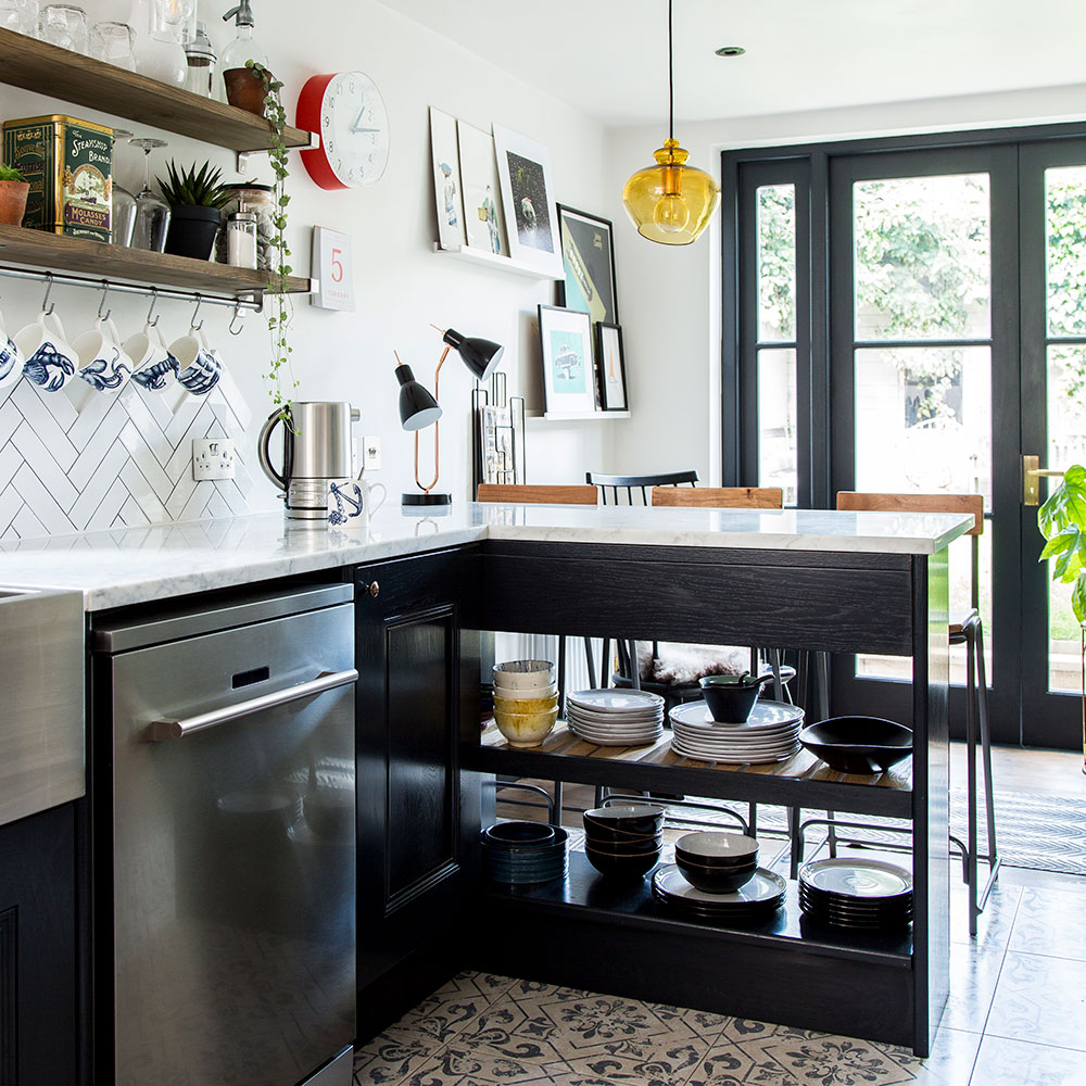 patterned floor kitchen with black cupboards and a white and grey marble counter-top, with wall-mounted shelves decorated with accessories and glasses