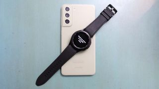 Samsung Galaxy Watch 4 Classic laying on a Galaxy S21 FE