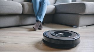 a robot vacuum in front of a sofa