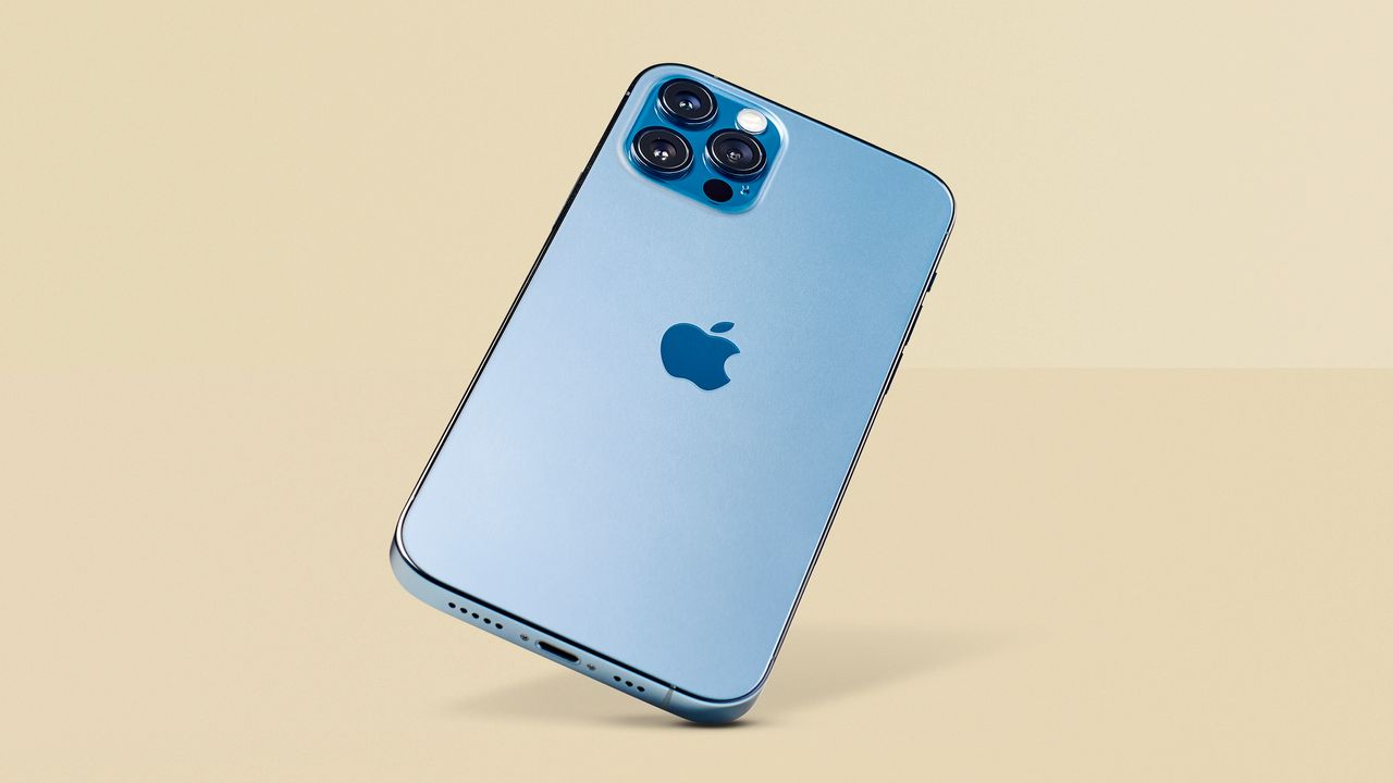 iPhone 12 Pro in blue finish, with the rear panel and camera visible, against a yellow background