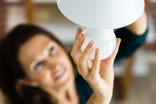 Woman changing LED lightbulb