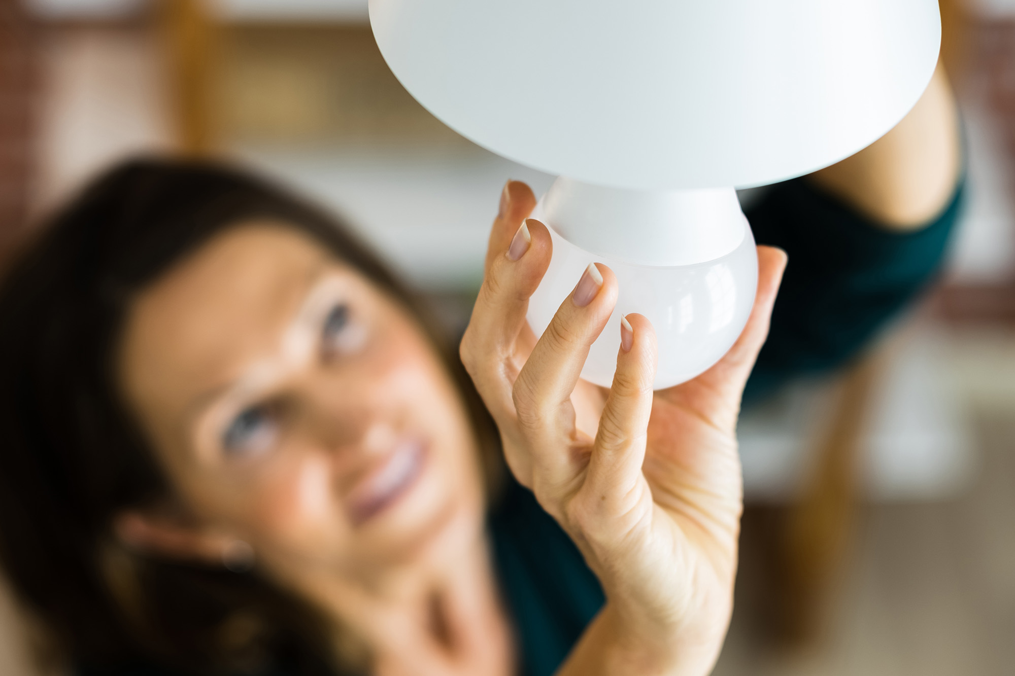 Woman changing LED lightbulb