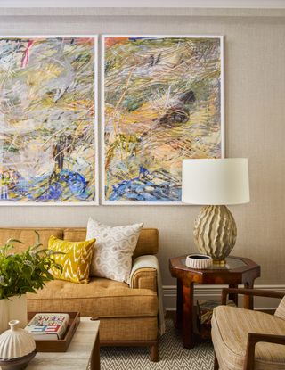 A living room with artwork on the walls and colorful decor