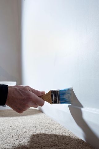 A paint brush cutting in on trim