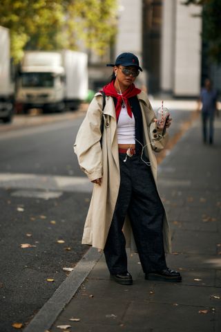 woman wearing trench coat, t-shirt, barrel jeans, and loafers