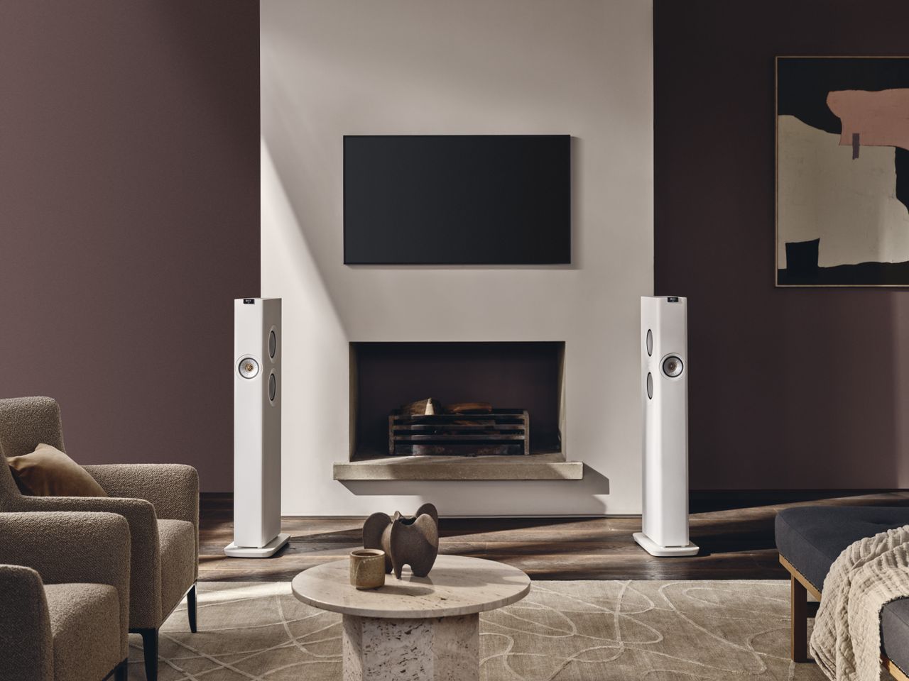KEF LS60 wireless speakers in a living room setting next to a fireplace