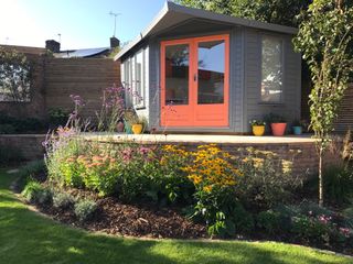 garden studio with brightly coloured doors painted in coral