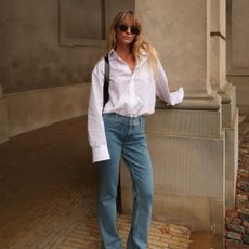 Jeanette Madsen in a white button down and jeans.