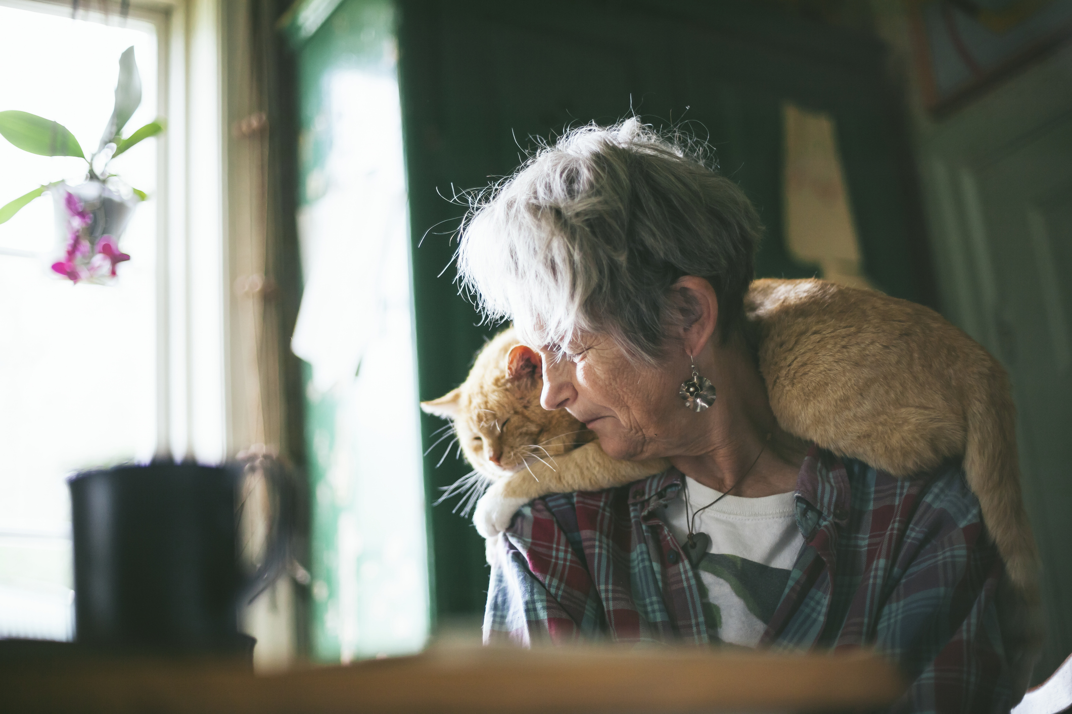 Senior woman with cat on shoulders