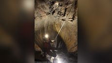 Archaeologist Lucia Castagna recovers the 5,600-year-old human skull at the top of a vertical shaft in the Marcel Loubens cave, in the Bologna area of northern Italy.