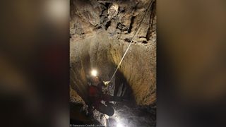 Archaeologist Lucia Castagna recovers the 5,600-year-old human skull at the top of a vertical shaft in the Marcel Loubens cave, in the Bologna area of northern Italy.