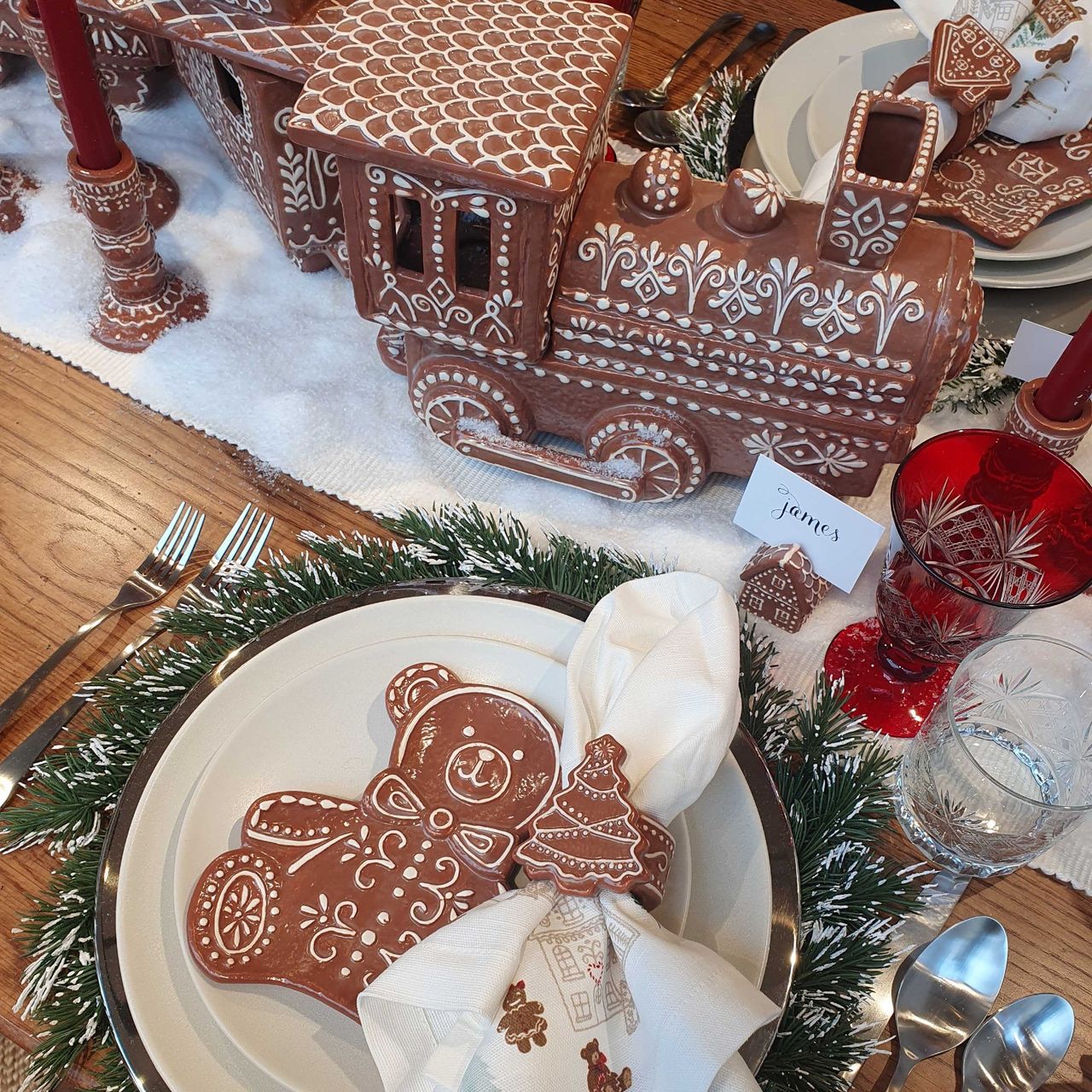 A set dining table decorated for Christmas with Pottery Barn's gingerbread-themed tableware