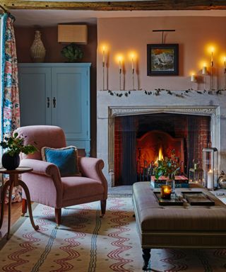 cozy living room with fireplace and lit taper candles on mantel