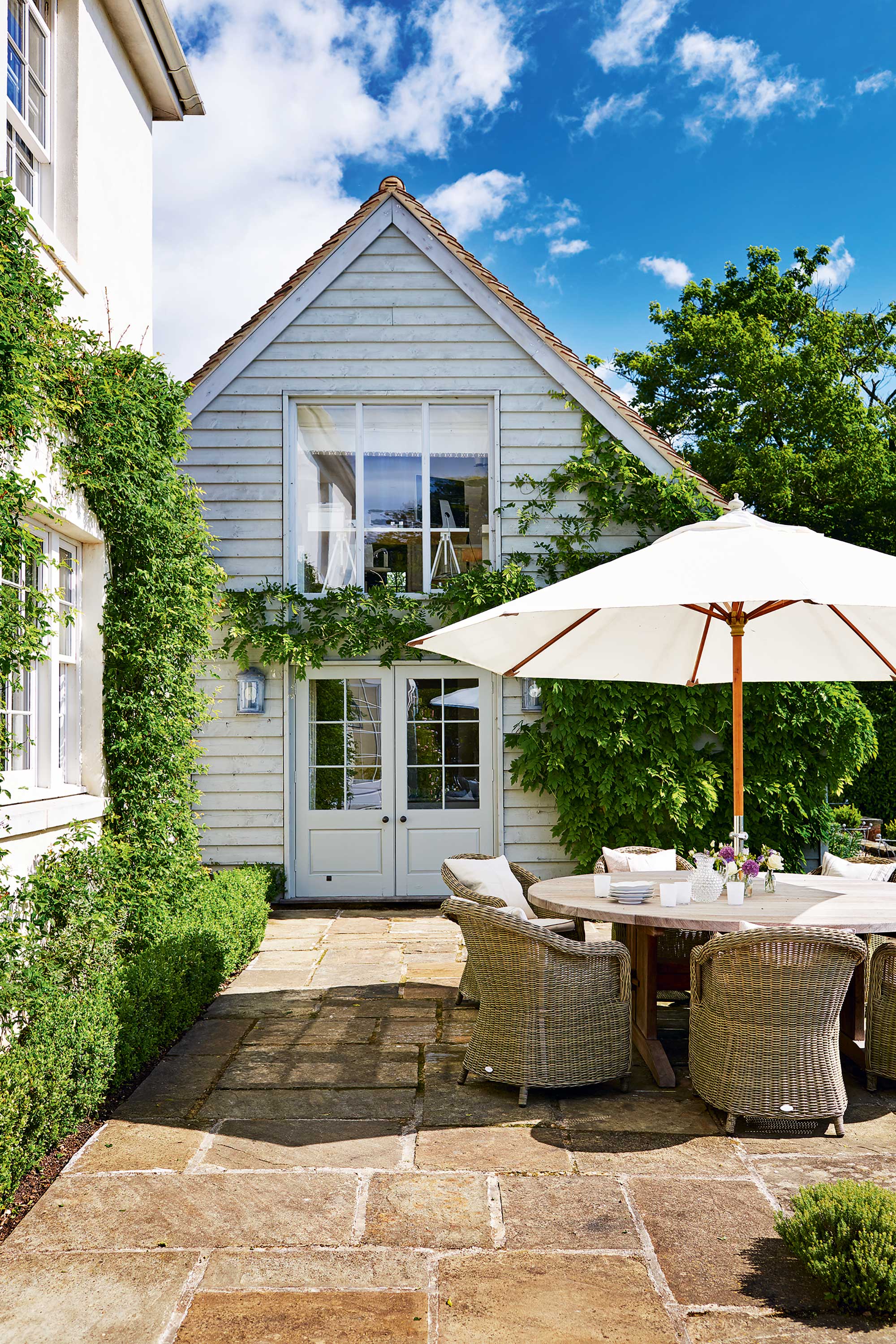 white parasol over outdoor dining table and chairs on patio