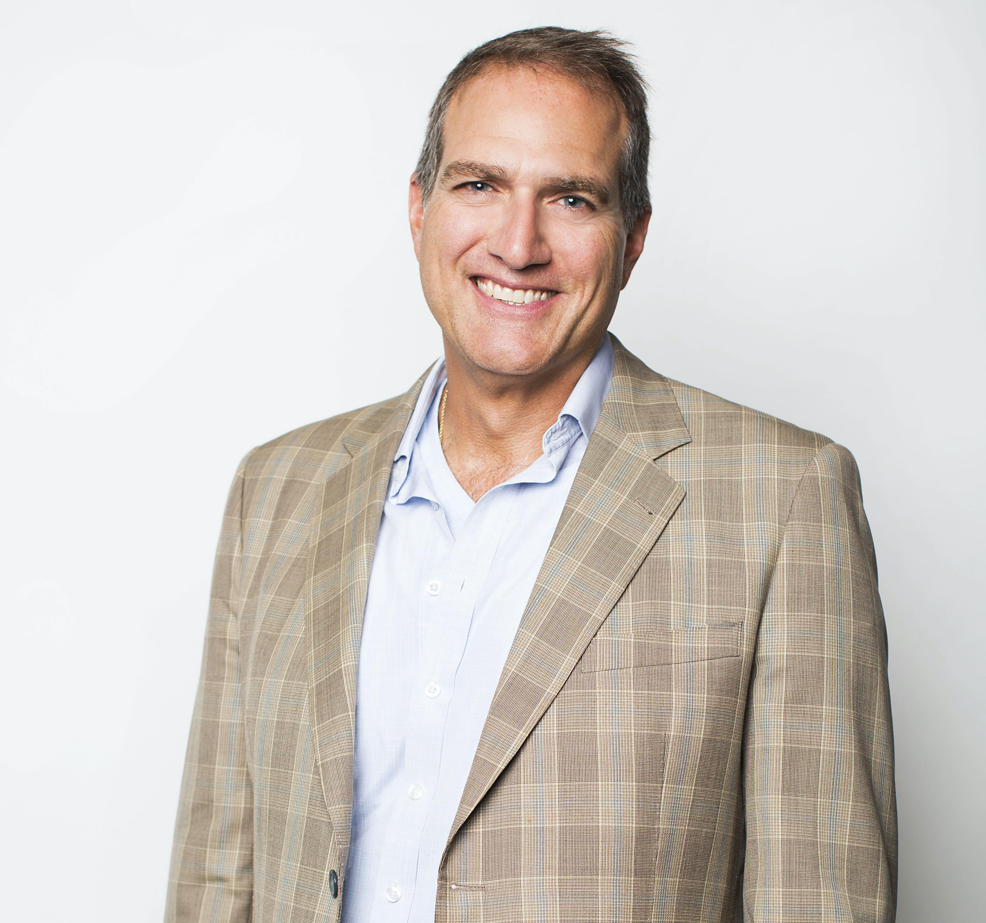 Smiling headshot of Carlo DiMarco in a sport coat.