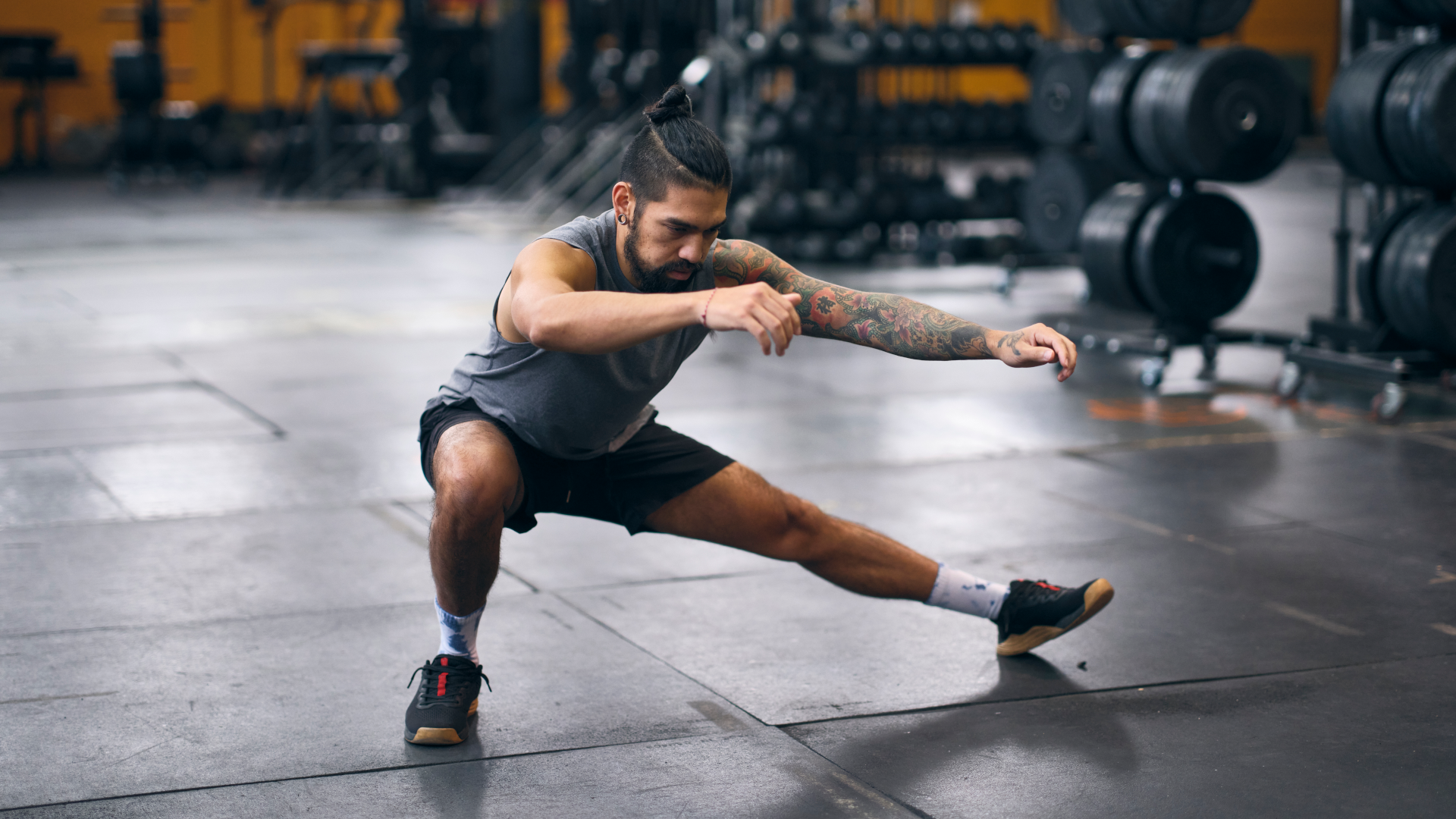 a man performing cossack squats at the gym