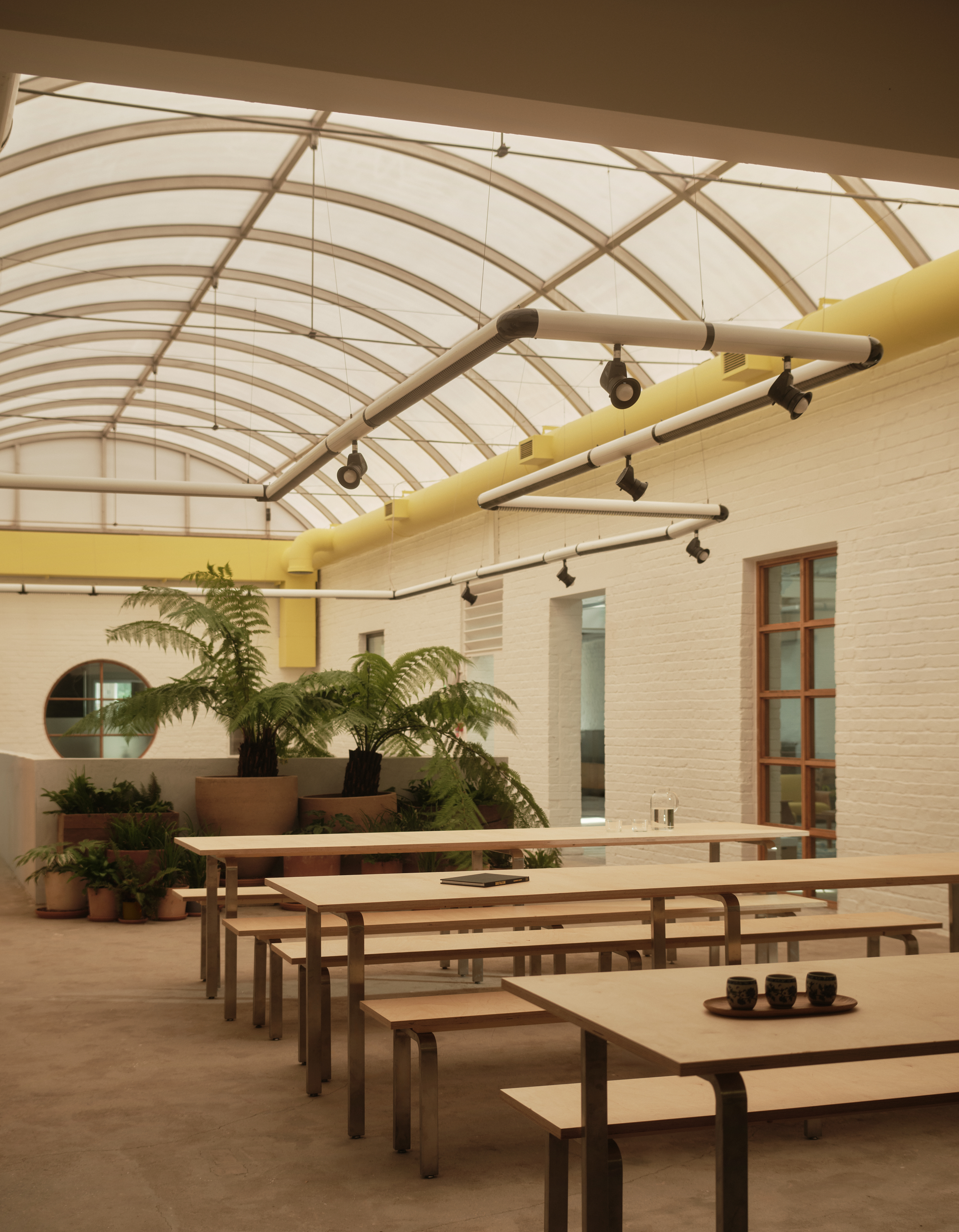 new Cubitts headquarters interior, refurbished warehouse type building with raw materiality and colour pops
