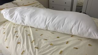 The Utopia Bedding Body Pillow on a made bed in our reviewer's bedroom.