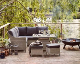 A rattan outdoor sofa set from Bramblecrest on decking by a lake