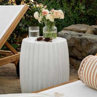 A white fluted side table on an outdoor patio from McGee & Co.