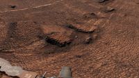 a reddish-brown landscape of soil and rocks covered in slightly raised hexagonal lines of nearly equal size