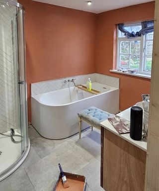 painting red bathroom with grey tiles and white bath tub