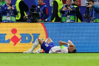 Kylian Mbappé of France lies injured on the grass during the UEFA EURO 2024 quarter-final match between Portugal and France at Volksparkstadion on July 5, 2024 in Hamburg, Germany.