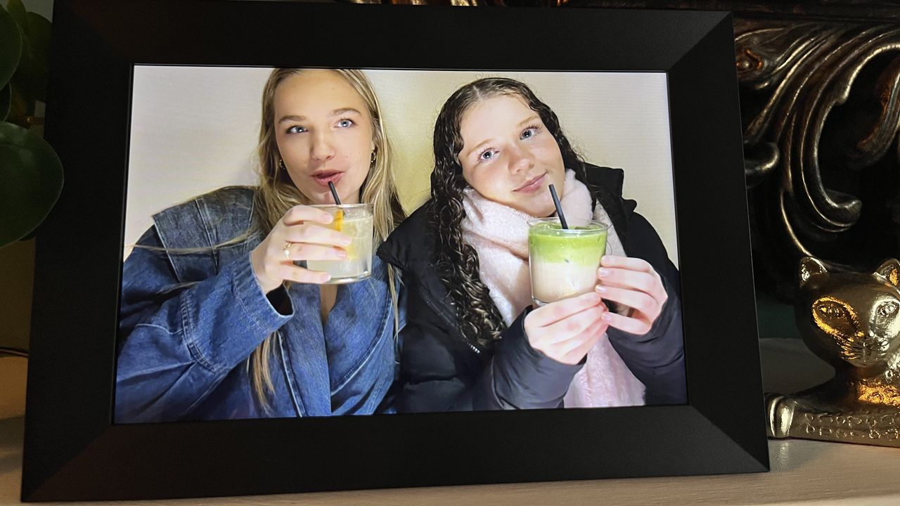 Aeezo 10.1-inch digital picture frame showing two girls sipping mocktails at cropped to fill the screen
