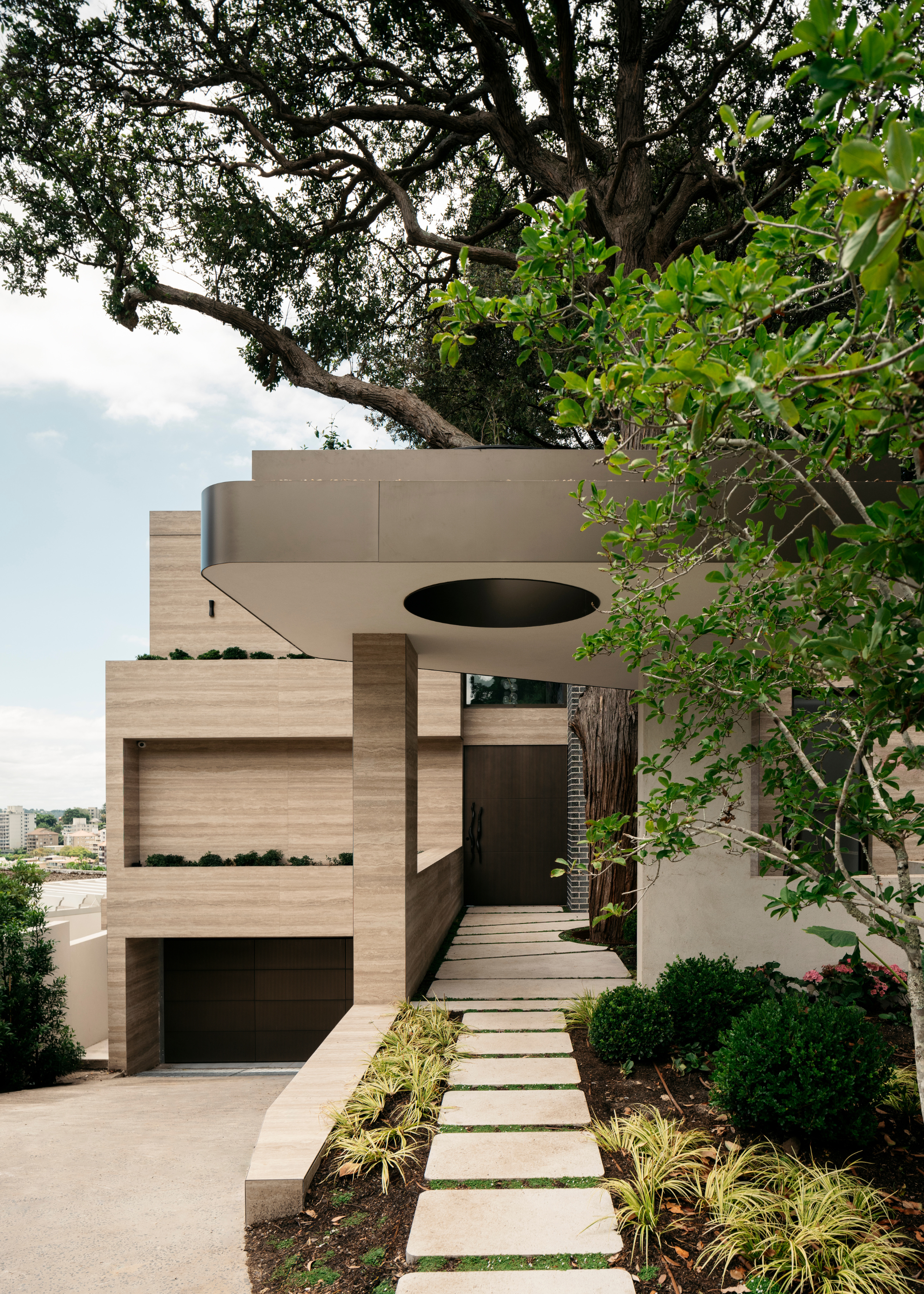 A front yard and a stone path leading to a modern home with two levels
