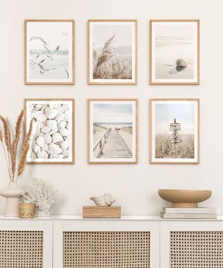 A small entryway with six coastal prints, a console table, and decor
