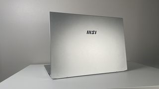 The MSI Prestige A16 AI+ seen from behind on a white table