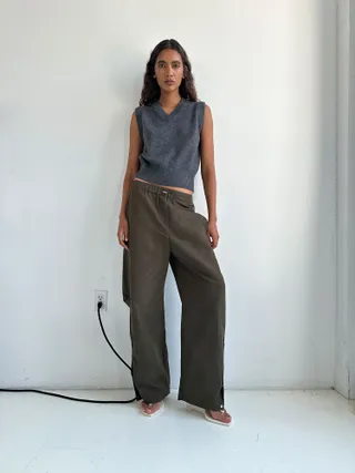 A model wears wide-leg trousers with a grey knitted vest for Paris Georgia campaign.