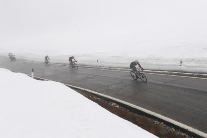 Riders coming through the fog on the top of the Passo Giau during stage 16 of the Giro d'Italia 2021